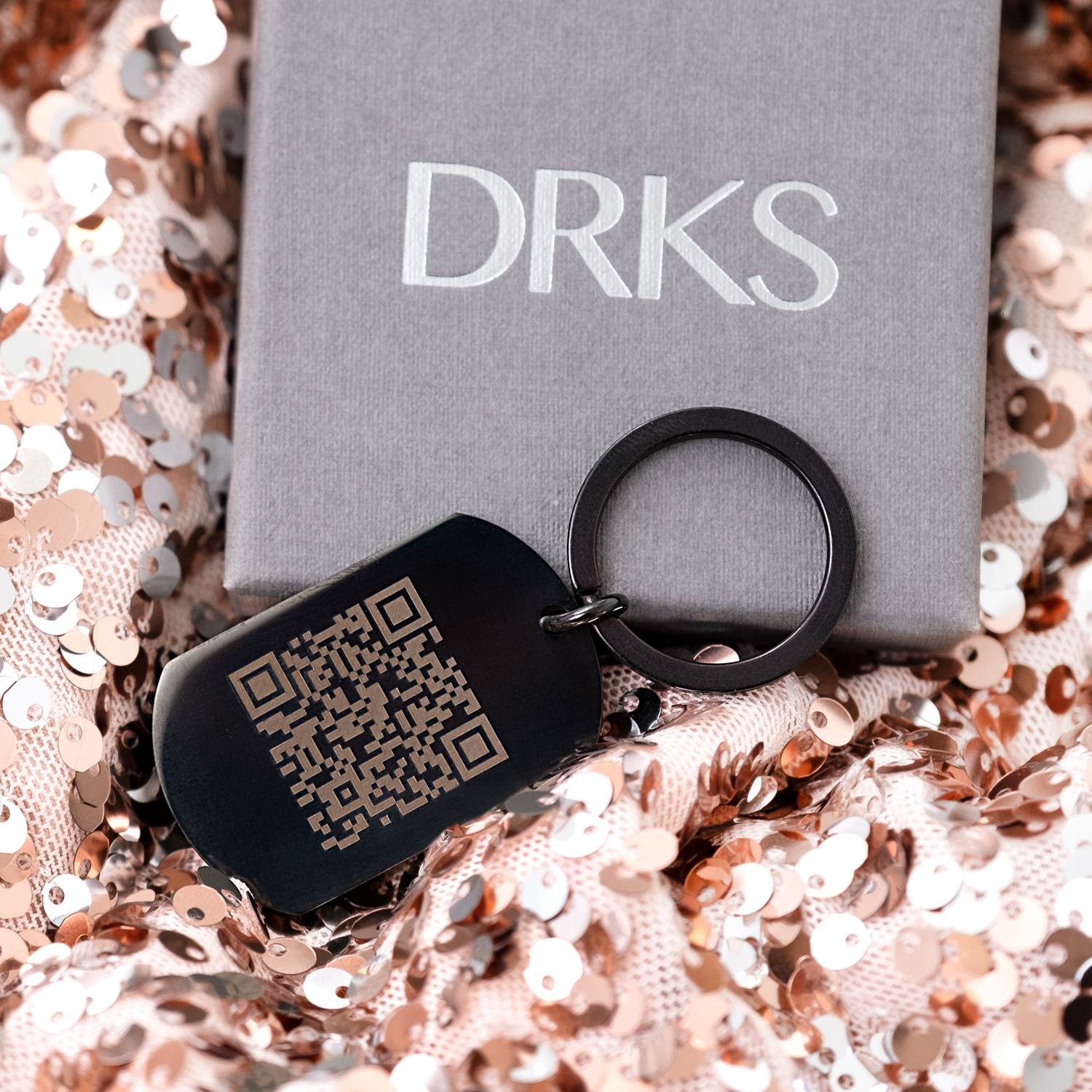 Zwarte sleutelhanger met qr code op roze achtergrond