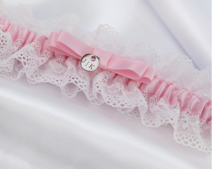 Roze kousenband met een persoonlijke gravering voor de bruid