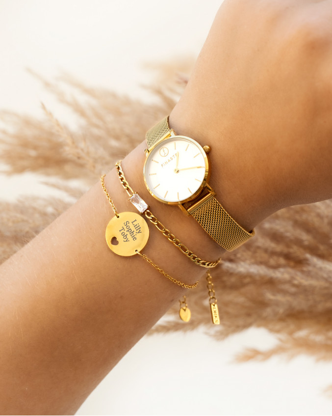 Mix van gouden armbanden en horloge