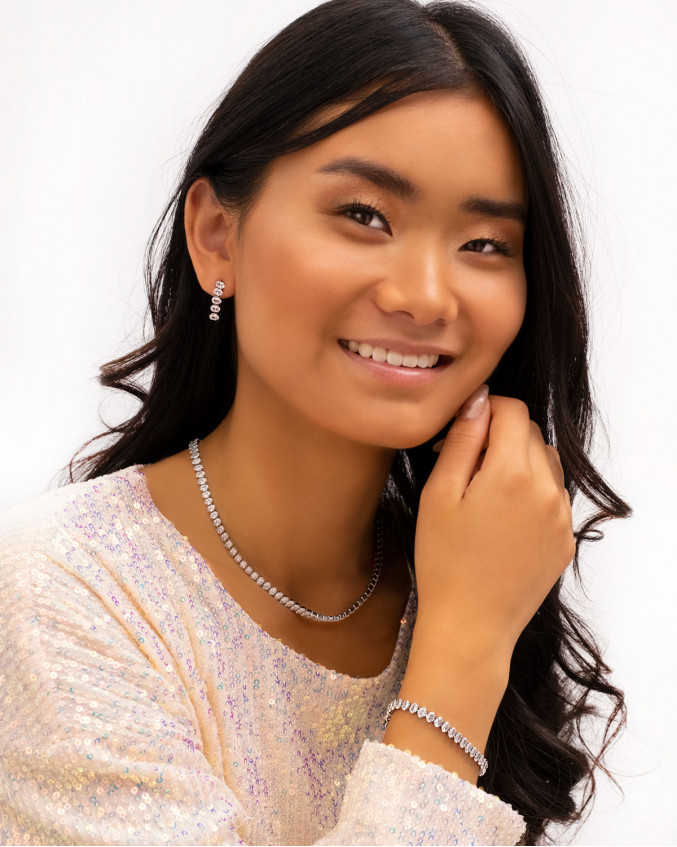 Model draagt look van zilveren tennis sieraden