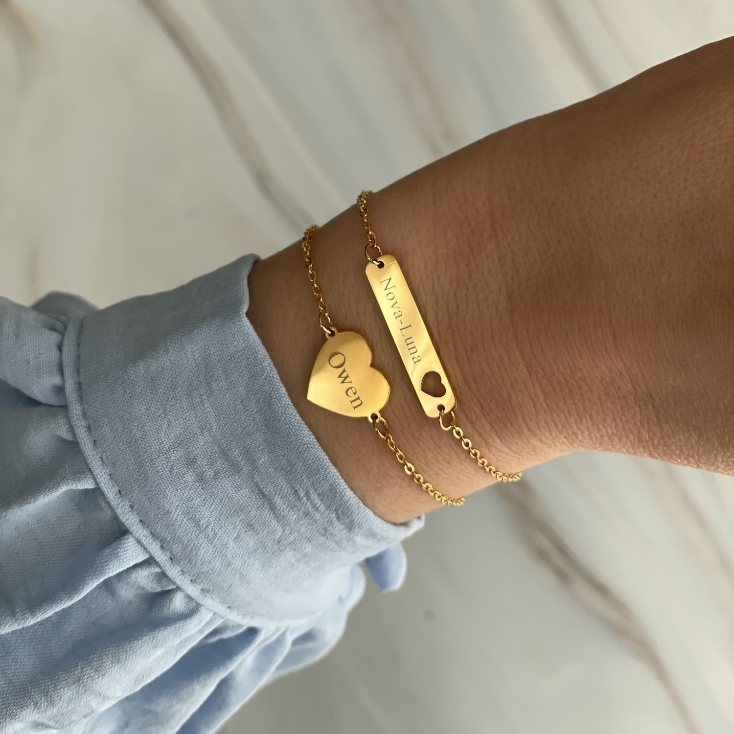 Gouden armbanden met gravering met blauwe blouse