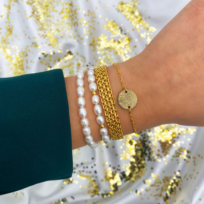 Vrouw draagt Fingerprint armband goudkleurig om pols