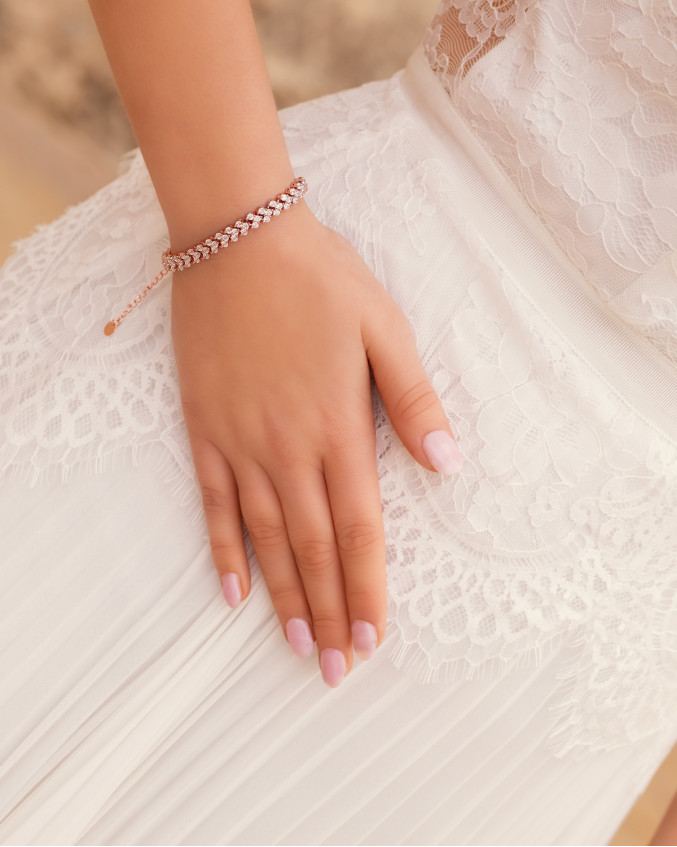 Bruid draagt rose gouden armband met steentjes