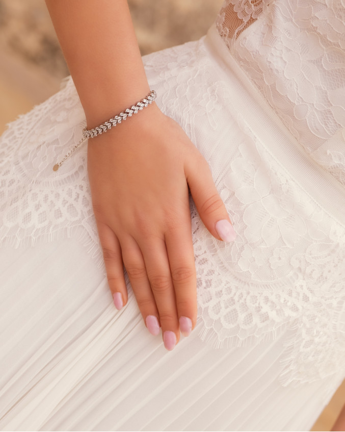 Bruid draagt zilveren armband voor de bruid met steentjes