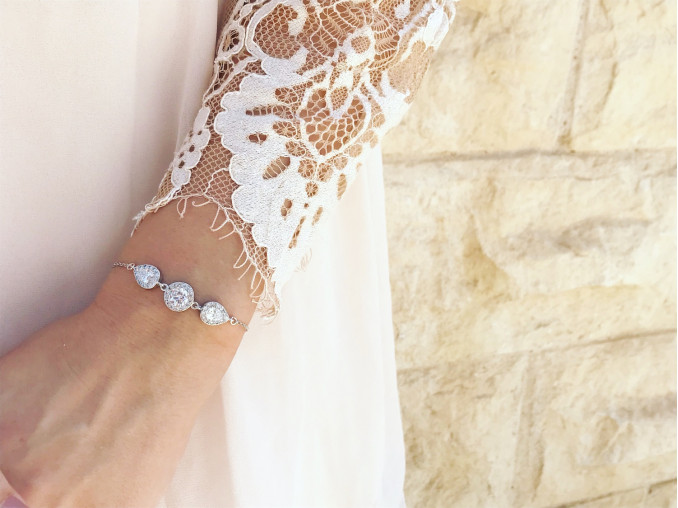 DRKS armband om pols van bruid met witte kanten jurk 