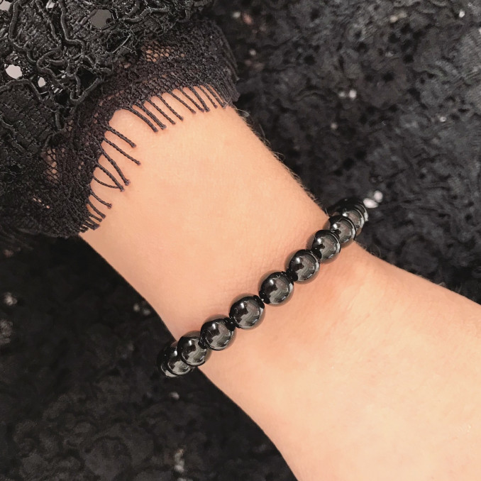 Vrouw draagt zwarte faux pearl armband van DRKS