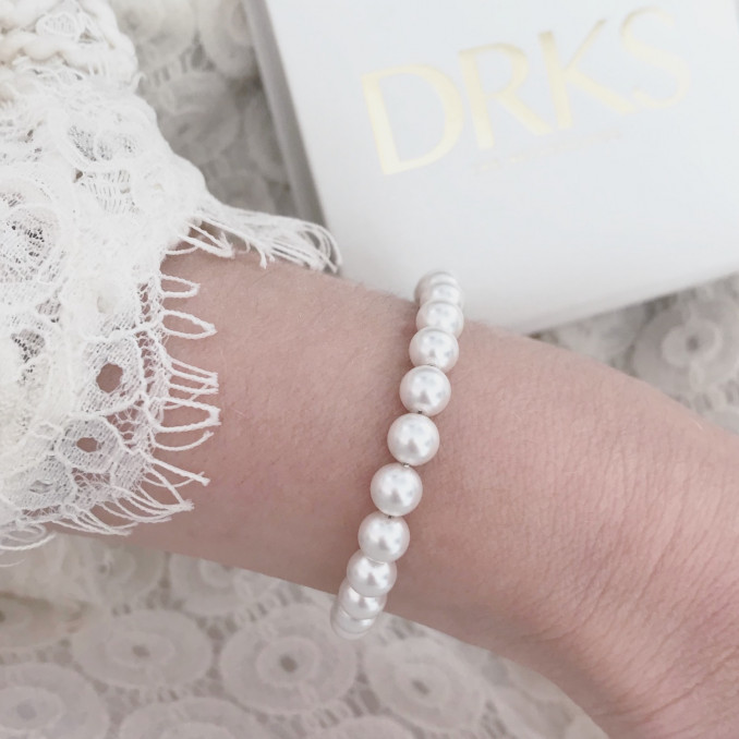 Vrouw met een ivoor faux pearls armband van DRKS