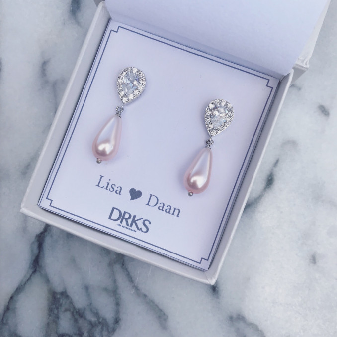 Elegante oorbellen van DRKS met roze faux pearls in sieradendoosje 
