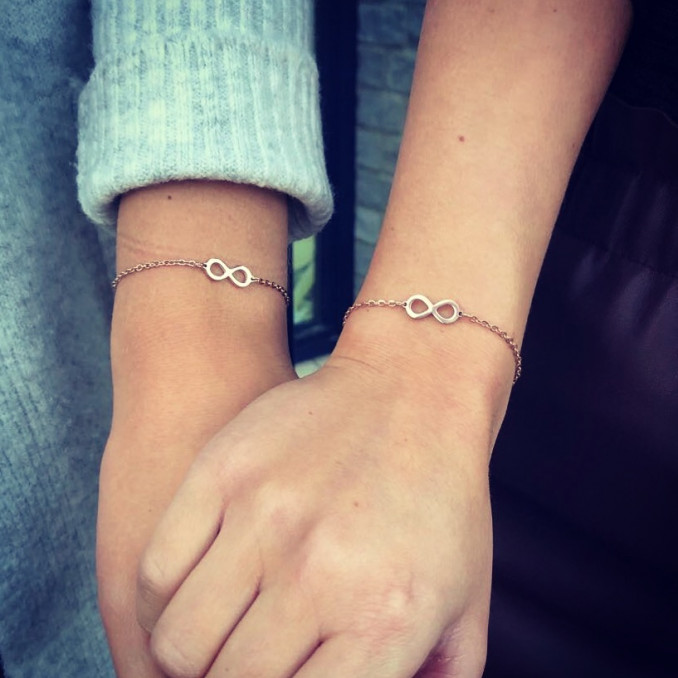 vrouwen dragen samen rose gouden infinity armband
