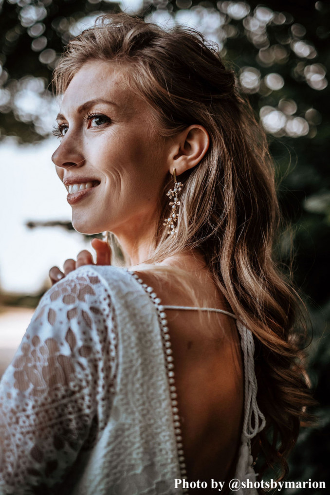 Bruid draagt gouden oorbellen in bohemian stijl