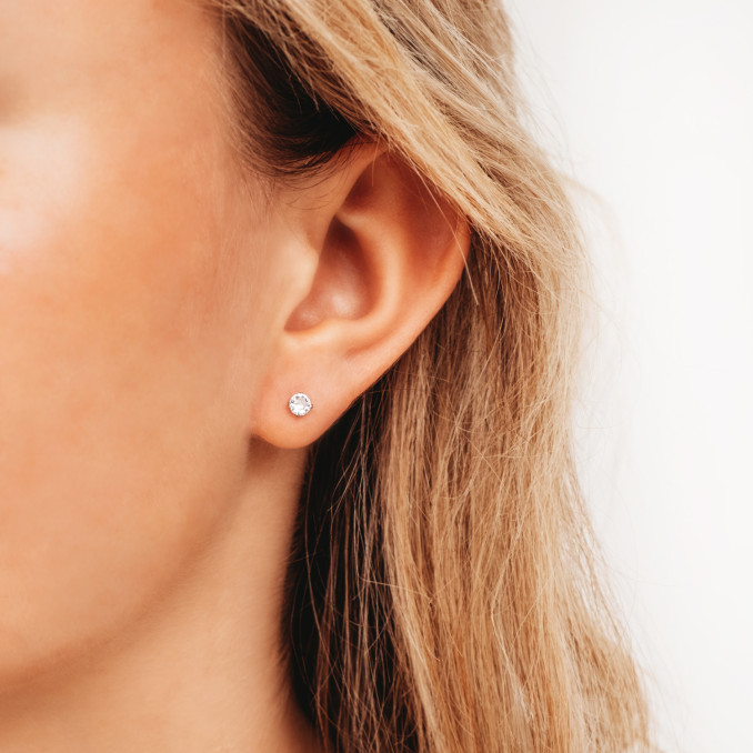 Zilveren subtiele oorknopjes bij vrouw met blond haar