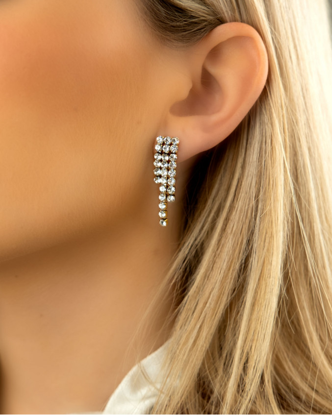 Vrouw draagt gouden tennis earrings luxury in oor