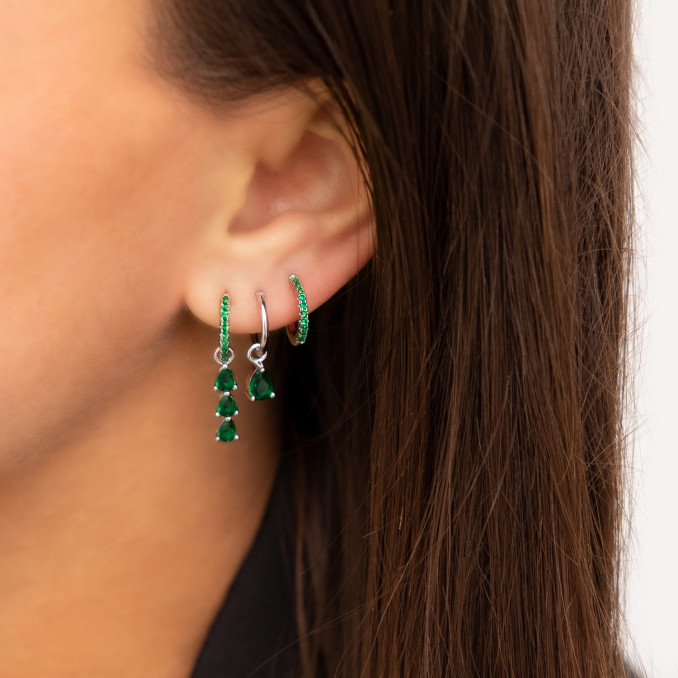 Vrouw draagt oorbellen met emerald steentjes