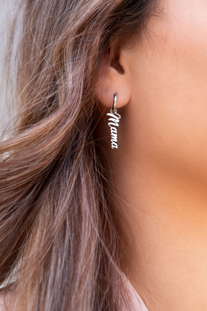 Trendy zilveren mama oorbellen in het oor van het model