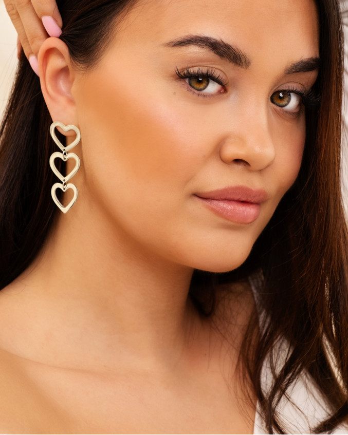 Model draagt zilveren hartjes oorbellen