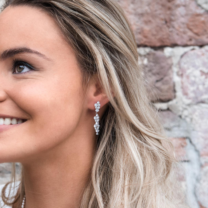 Vrouw draagt mooie sparkle oorbellen in het oor voor een mooie look