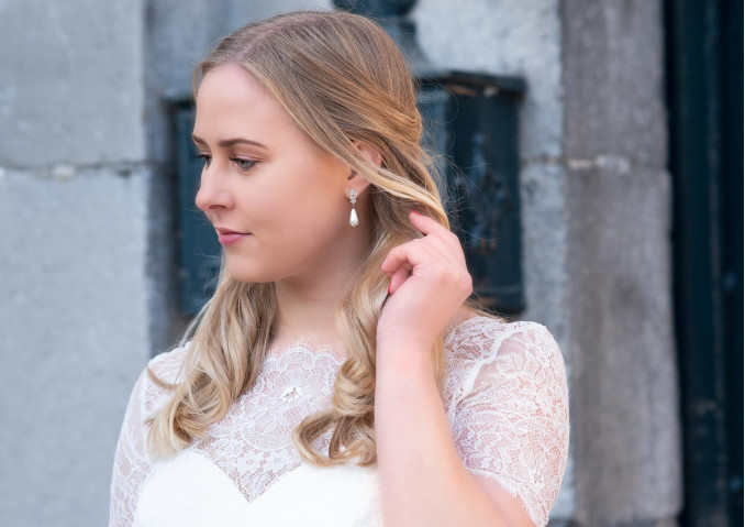 Vrouw draagt mooie parel oorbellen in het oor voor een complete look