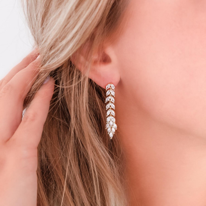 Vrouw draagt goud kleurige bruids oorbellen in oor