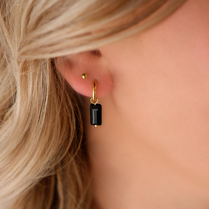 gouden stud oorbellen in het oor voor een trend look
