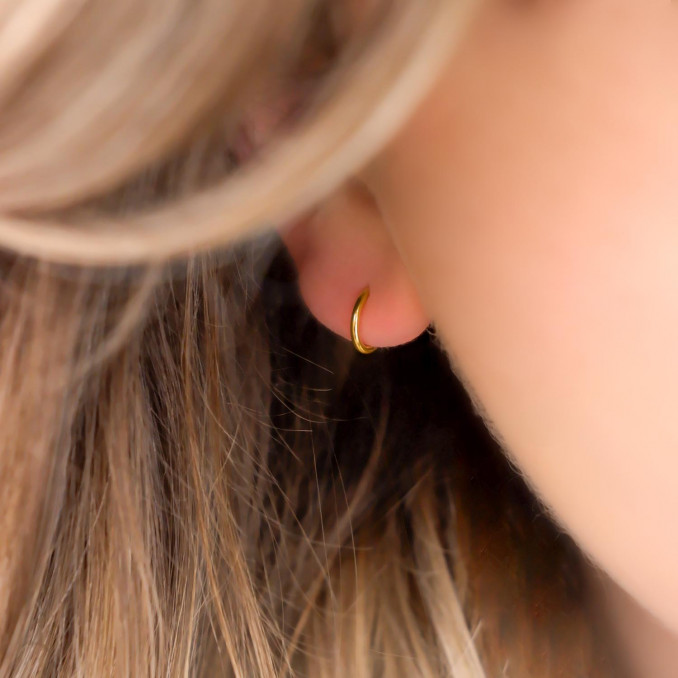 Vrouw draagt 10 mm gouden oorringen