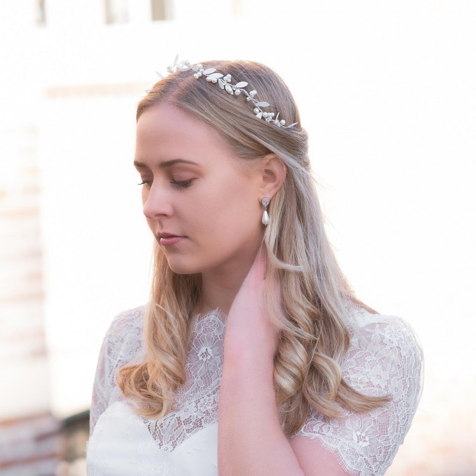 Bruid draagt mooie faux pearl oorbellen in het oor voor complete look