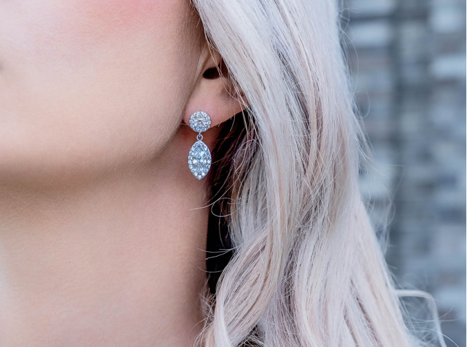 Blonde vrouw draagt luxe oorbellen met sparkle hanger 