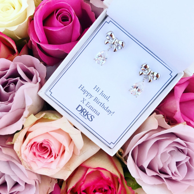 Zilveren bow oorbellen in een sieradendoosje met rozen