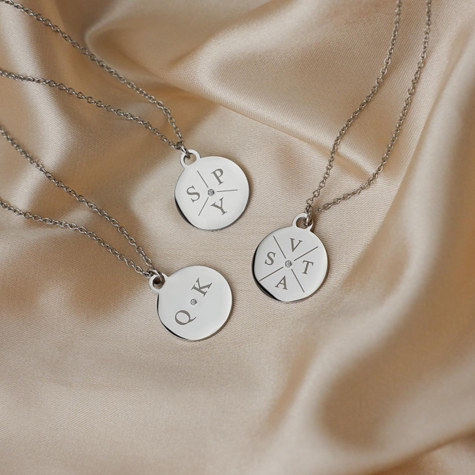 Drie zilveren initialen kettingen op satijn