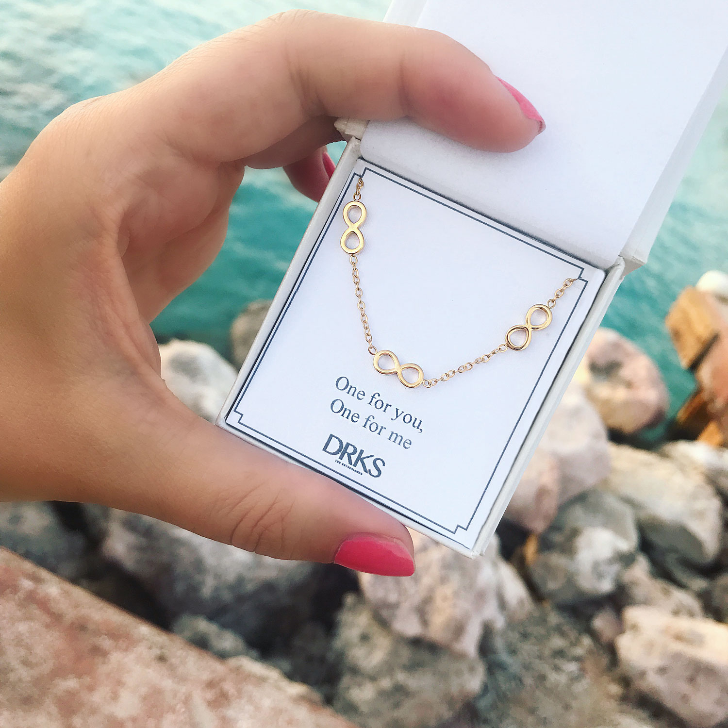 gouden infinity ketting in een sieradendoosje om het strand