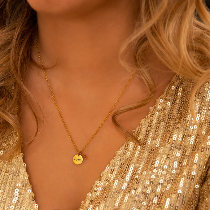 Model draagt gouden graveerbare ketting met birthstone steentje
