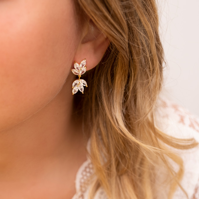Vrouw draagt gouden bruids oorbellen met steentjes