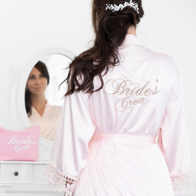 Meisje draagt roze kimono met kant voor bride's crew