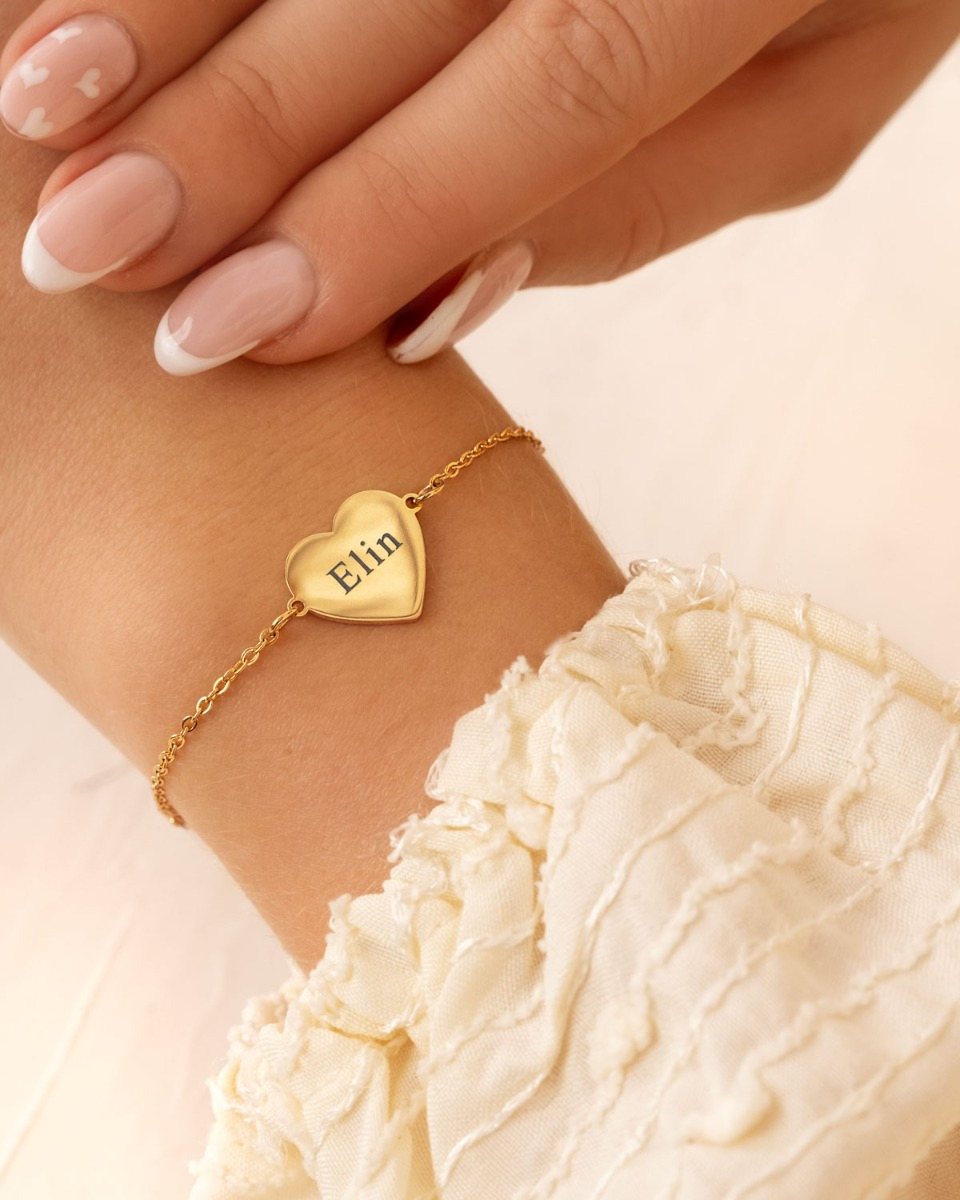 Gouden hartjes armband met naam bij model
