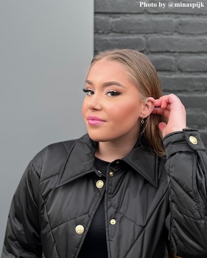 Model draagt de little glover oorbellen in het goud.