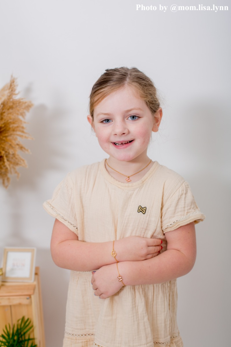 influencer kindje draagt armbandje hartjes goudkleurig