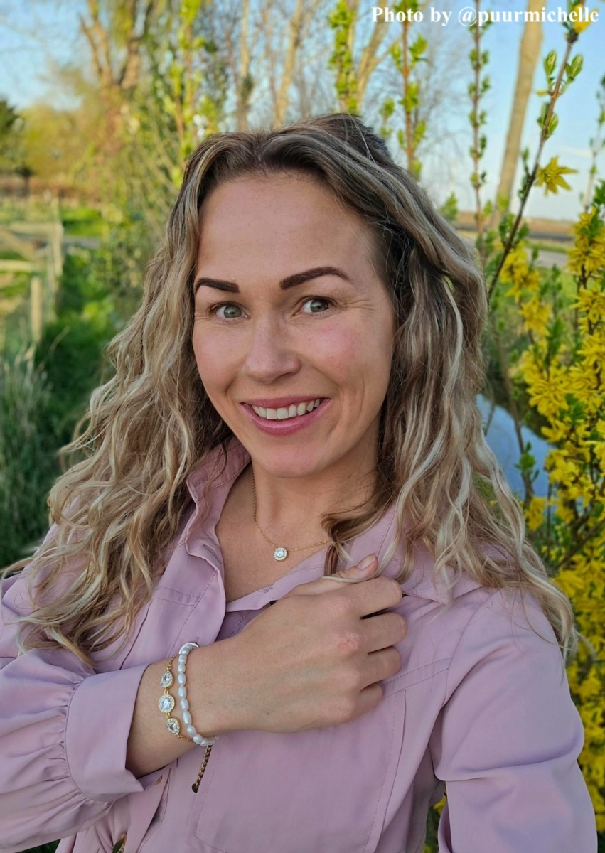 Influencer met goud/parel armbanden en ketting
