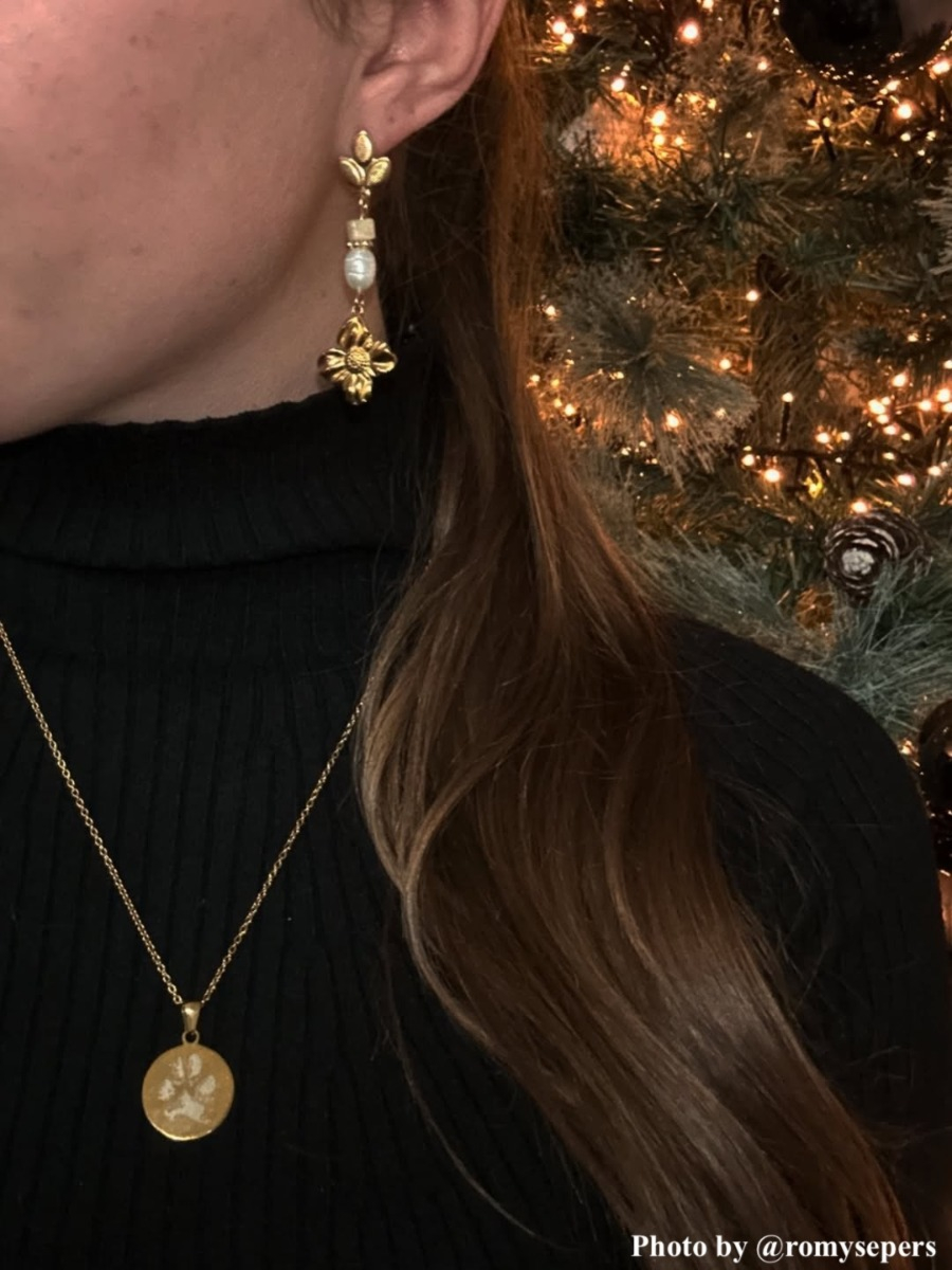 influencer draagt goudkleurige hondenpoot ketting gegraveerd