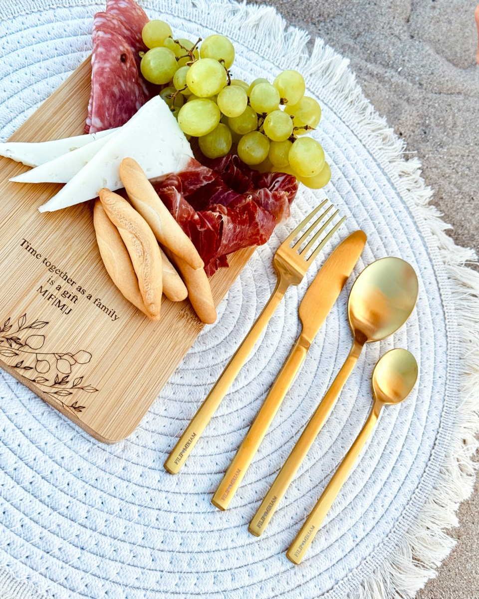 gouden bestekset met gravering met houten plankje met eten