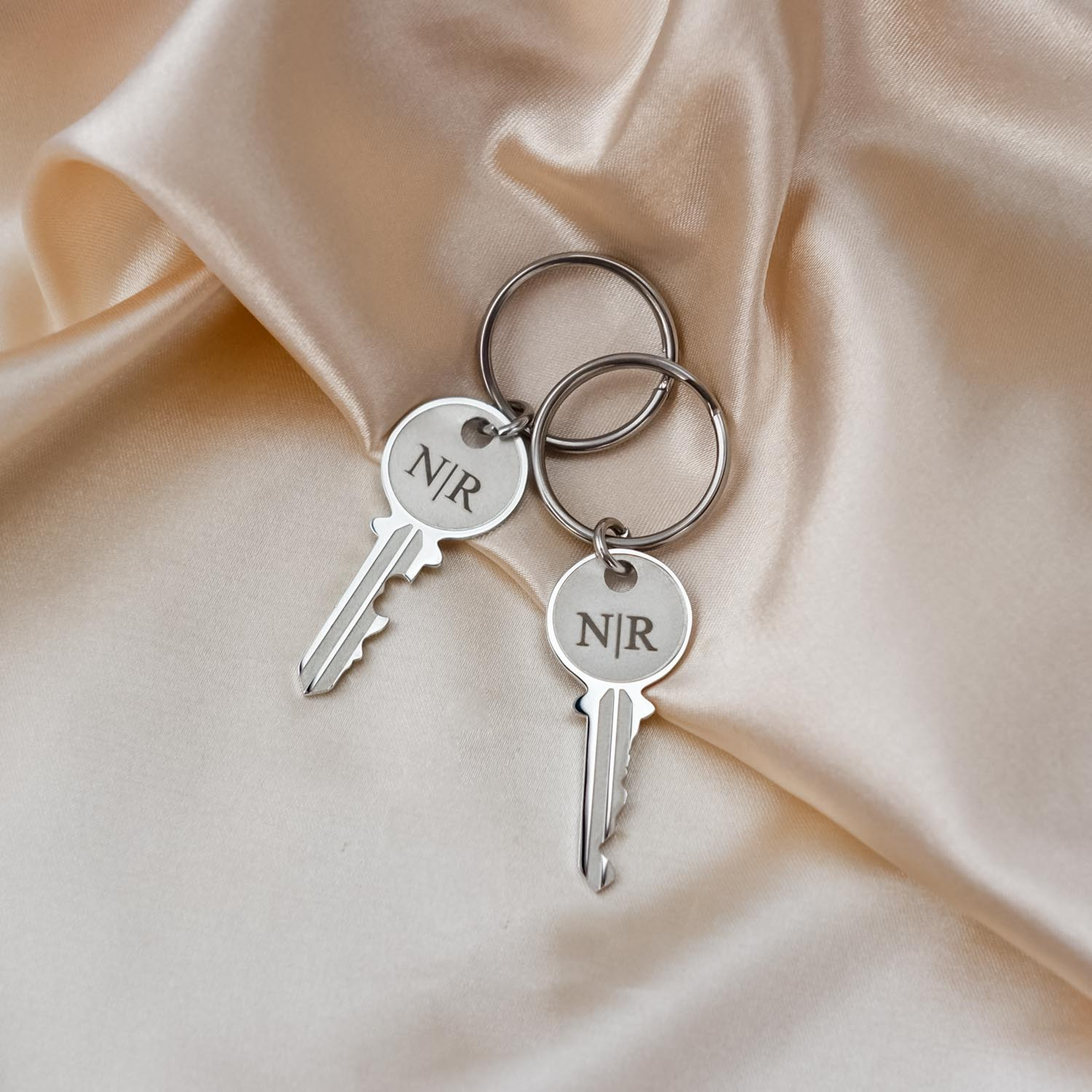 Zilveren sleutelhangers key op satijn met gravering