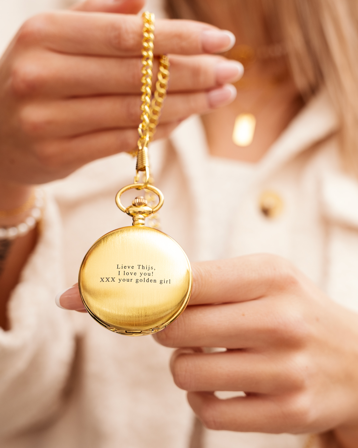 Model houdt gouden pocket watch vast