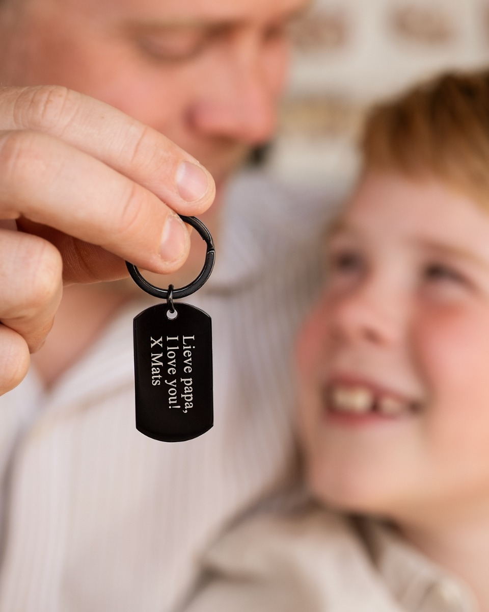 vader en zoon met zwarte sleutelhanger met tekst