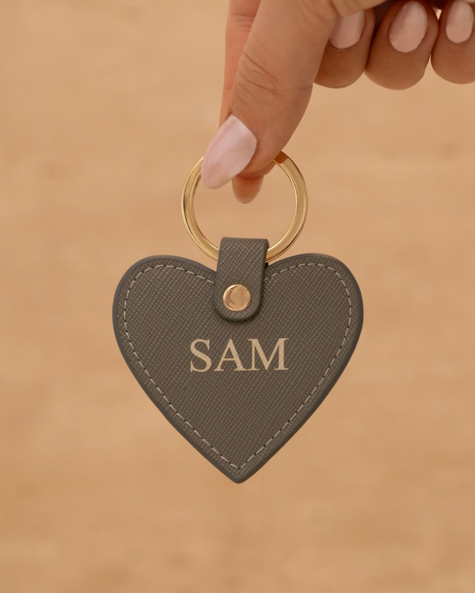grijze sleutelhanger met naam in hand
