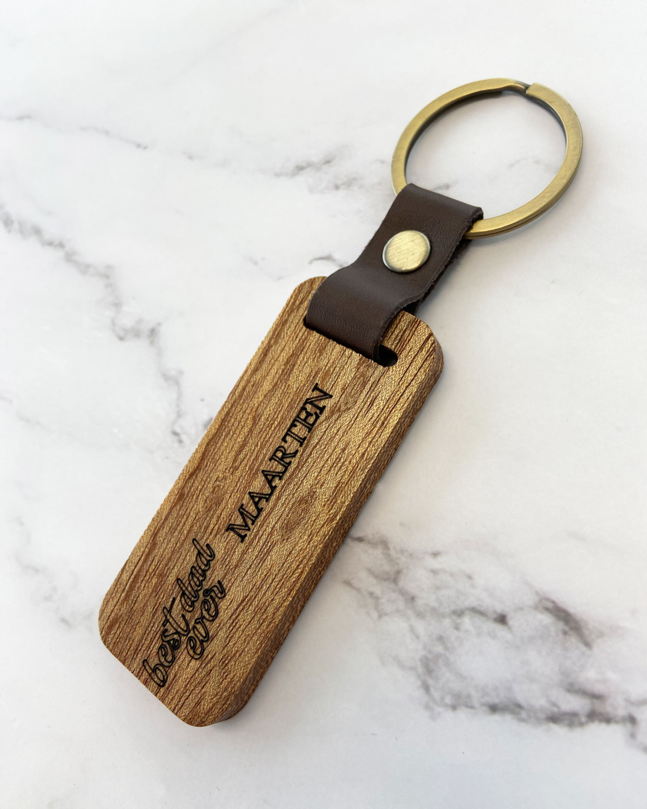 Houten sleutelhanger met naam op marmeren ondergrond
