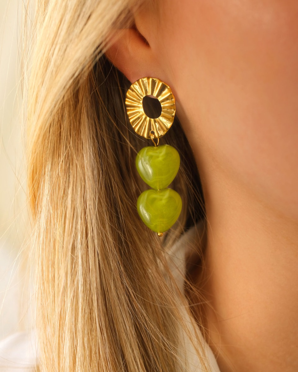 Model met groene hartjes oorbellen