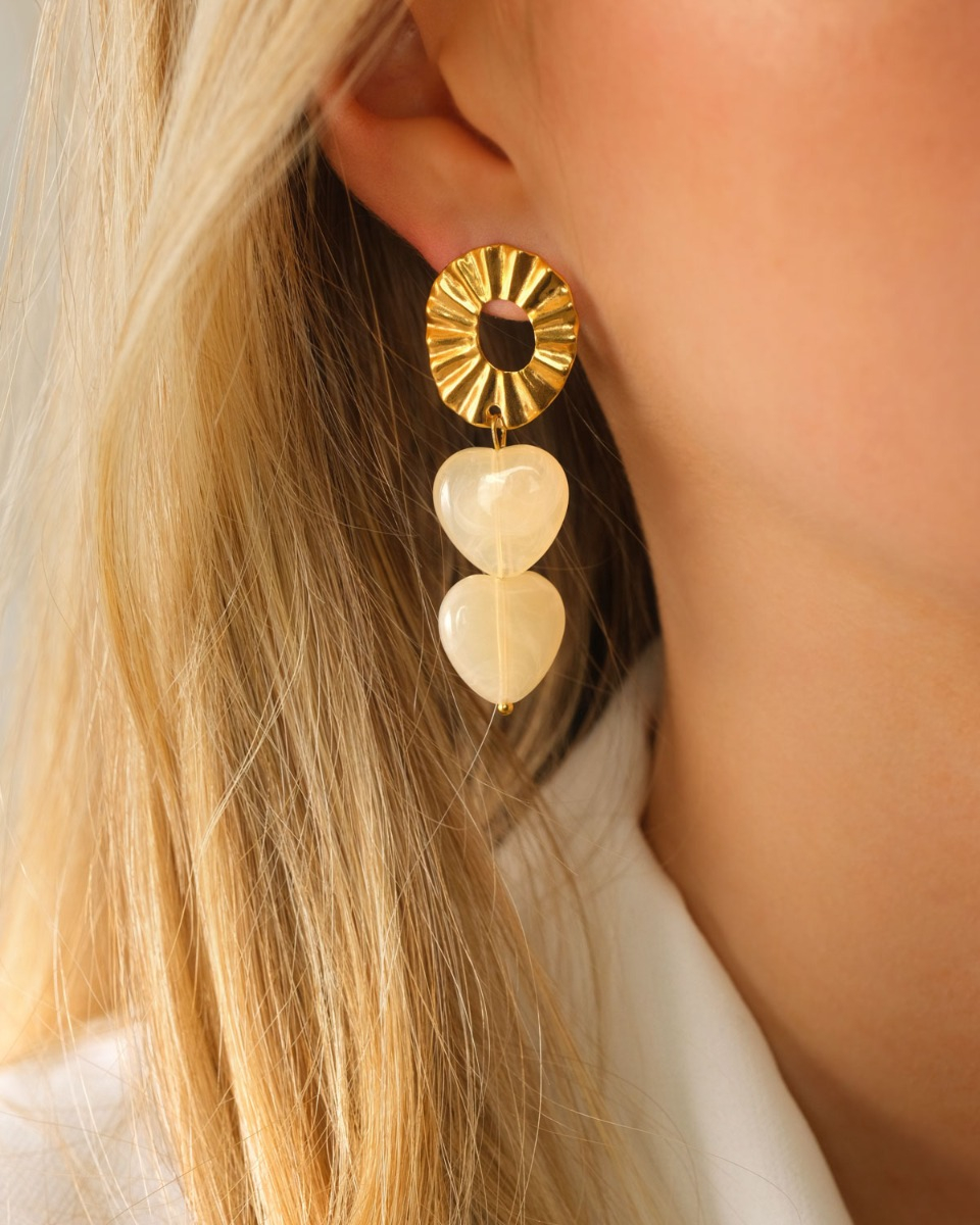 Model met witte hartjes oorbellen