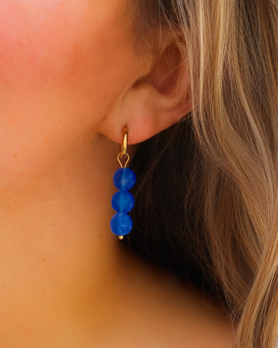 Gouden oorringetjes met blauwe steentjes