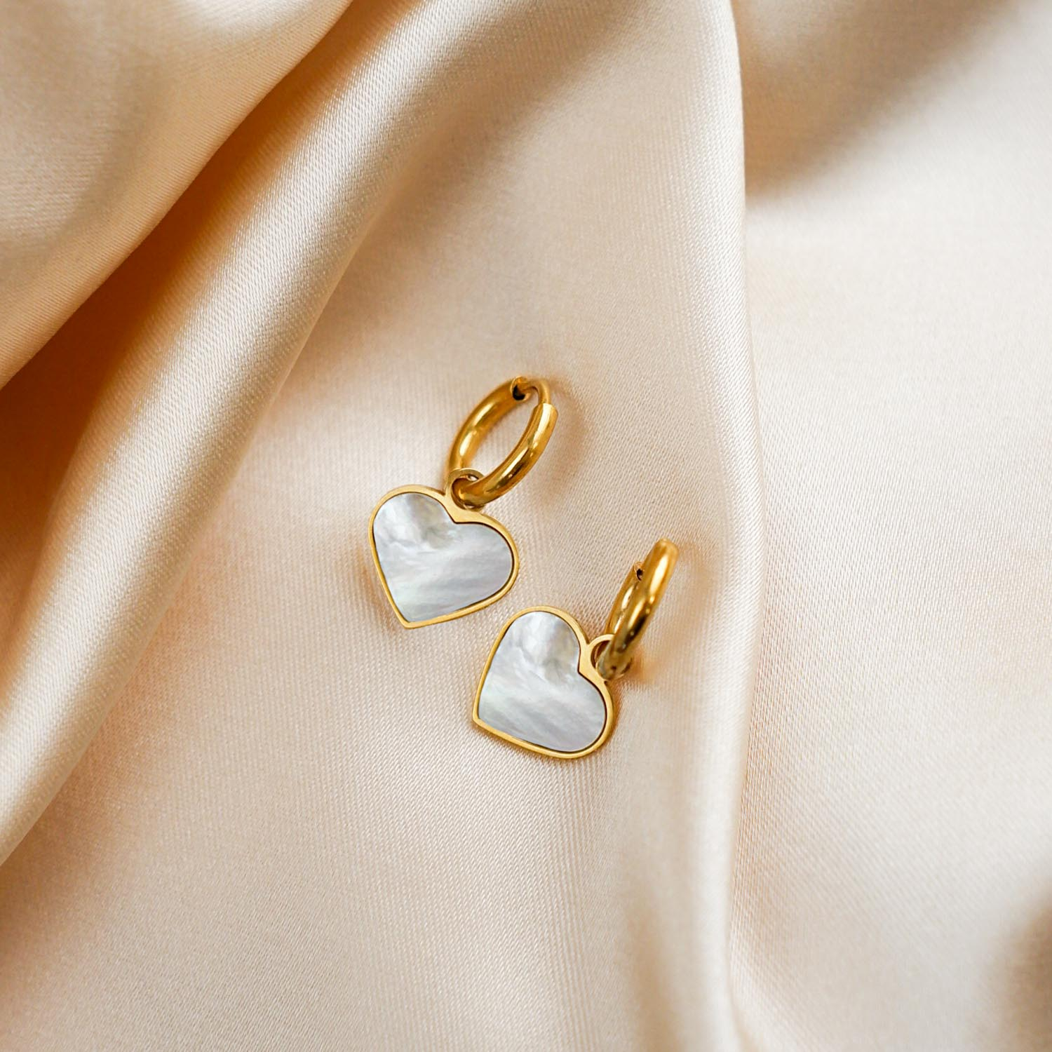 Gouden sea shell hartjes oorbellen op satijn