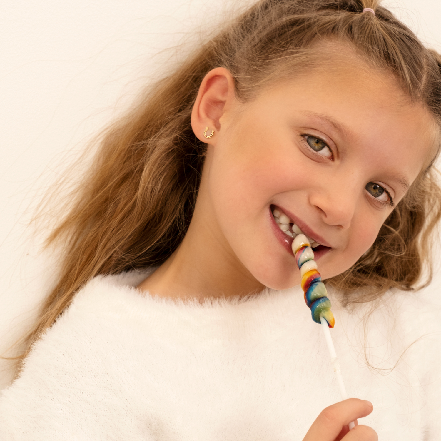Meisje draagt gouden kids oorbellen