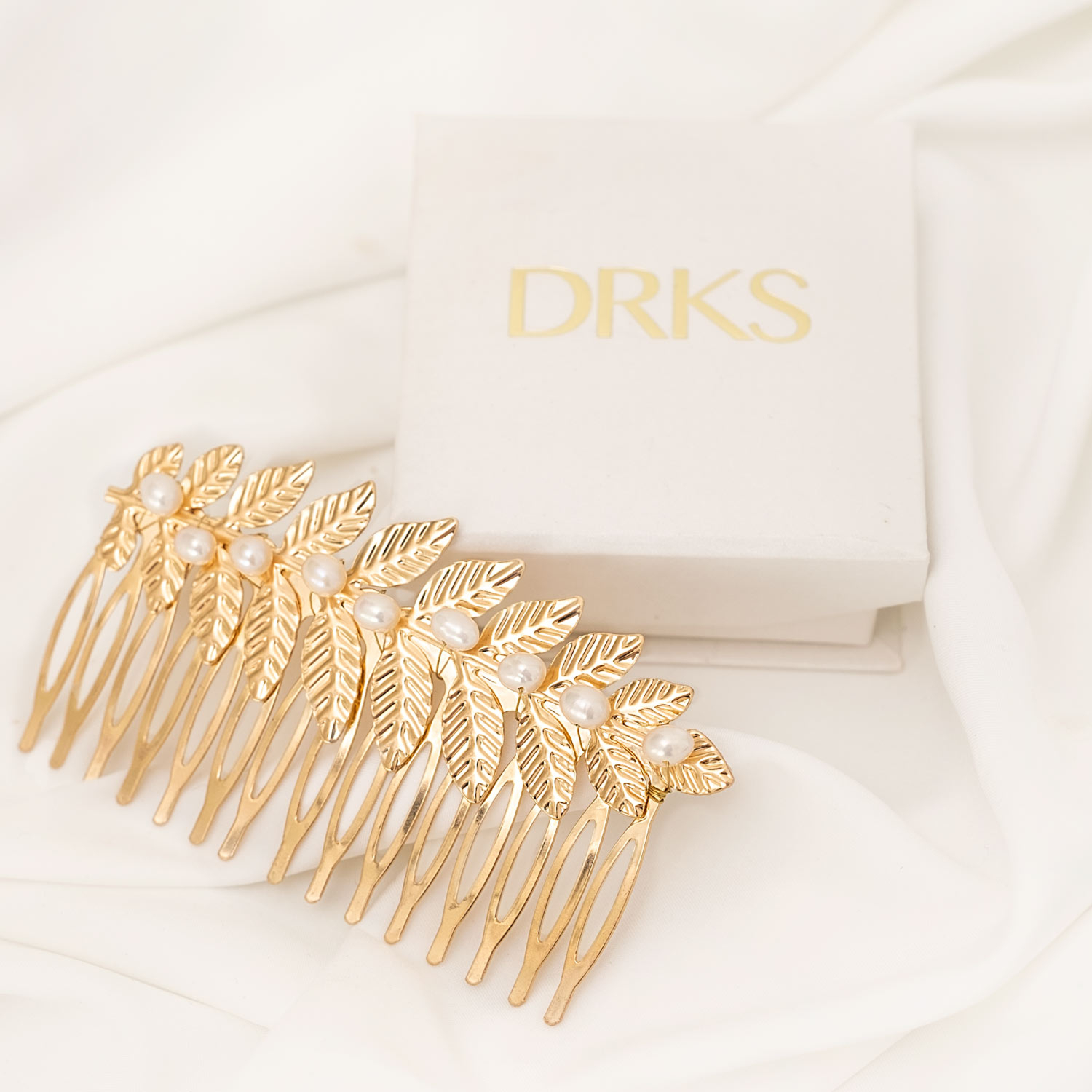 Gouden bohemian haaraccessoire op wit satijn met sieradendoosje