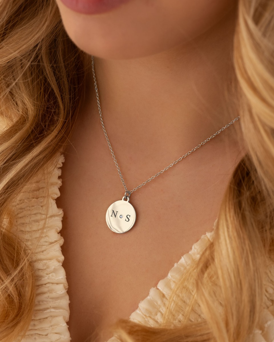 zilveren ketting met twee letters en steentje in het midden